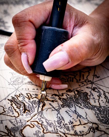 Close up of a person burning map on wood