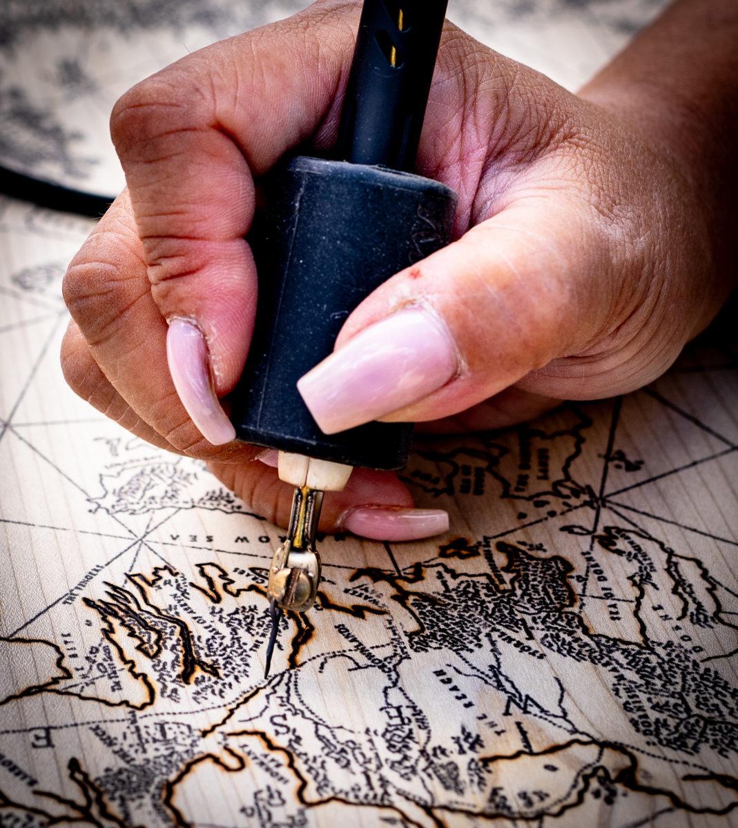 Close up of a person burning map on wood