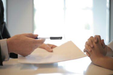 Two people signing a contract